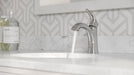 Pfister Weller single-control bathroom faucet in polished chrome, installed on a marble countertop in a contemporary bathroom with neutral-toned decor.