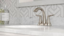Pfister Weller 2-handle 4-inch centerset bathroom faucet in brushed nickel, installed on a white marble countertop.