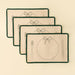 Stacked Bon Appetit placemats tied with a pale ribbon, showing green edging and embroidered place-setting details