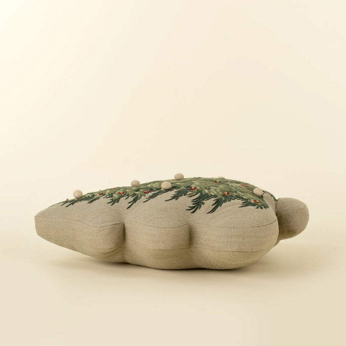 Christmas tree pillow lying flat, showing its padded profile, curved edges and neutral fabric sides
