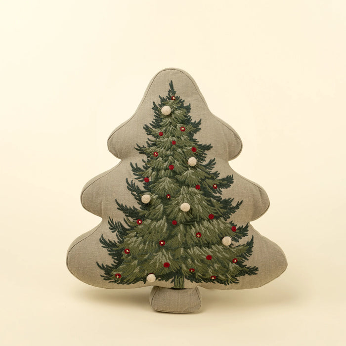 Indaba tree-shaped pillow with green evergreen embroidery, red accents and cream pom-pom details on natural fabric