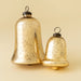 Small and large gold glass bell ornaments displayed together to show their size difference
