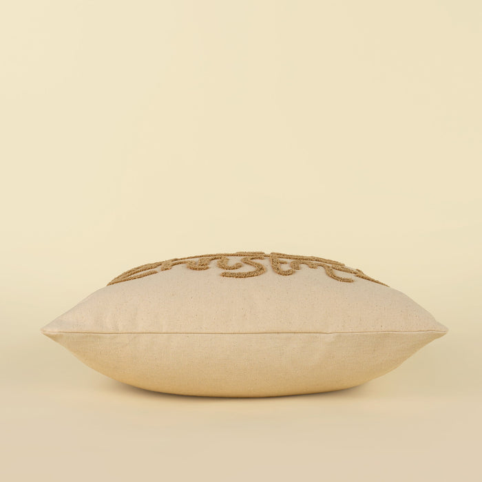Side profile of the filled Jolly Christmas pillow showing its shape and tufted lettering