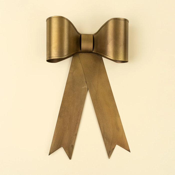 Large gold-toned iron bow with broad curved loops, a central band and long notched ribbon tails