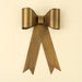 Large gold-toned iron bow with broad curved loops, a central band and long notched ribbon tails
