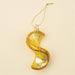 Yellow spiral lemon glass ornament with glittered rind, a gold-tone cap and hanging cord against a cream background