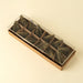 Green paper tree garland neatly arranged inside a long rectangular gift box