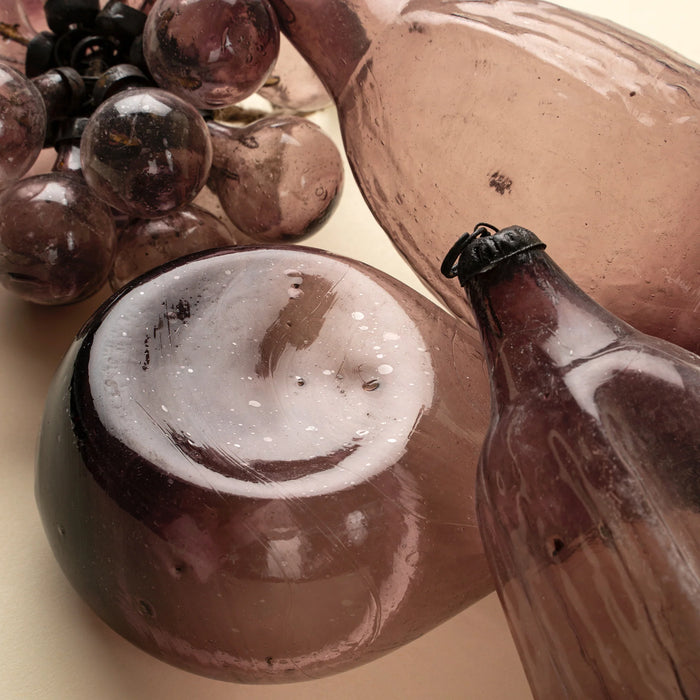 Close-up of plum glass decorations showing the bubble cluster alongside rounded and elongated glass forms