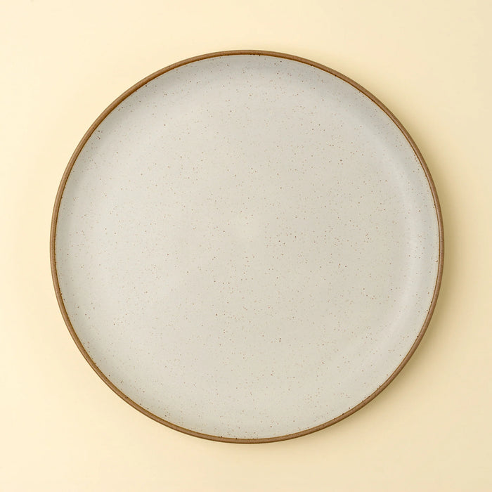 Top view of an Indaba Rowe ivory dinner plate showing its round shape and speckled glaze
