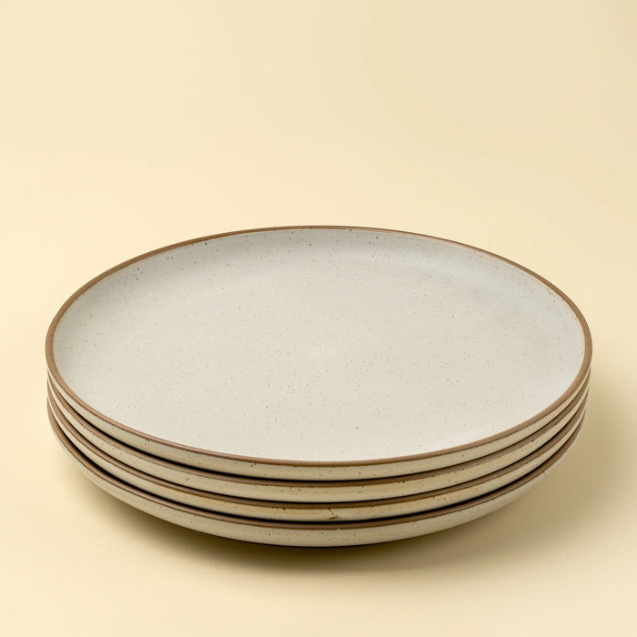 Four stacked Indaba Rowe ivory stoneware dinner plates with contrasting unglazed rims