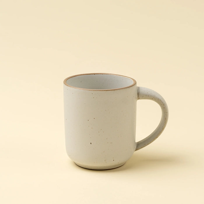 Indaba Rowe ivory stoneware mug with a speckled glaze, rounded handle and contrasting brown rim