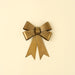Small iron bow ornament with a rustic brass finish, layered ribbon loops and two long notched tails.