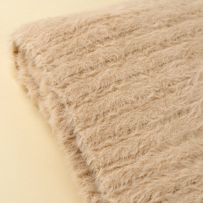 Close-up of the oat Snug Throw showing its textured knit surface and finished edge