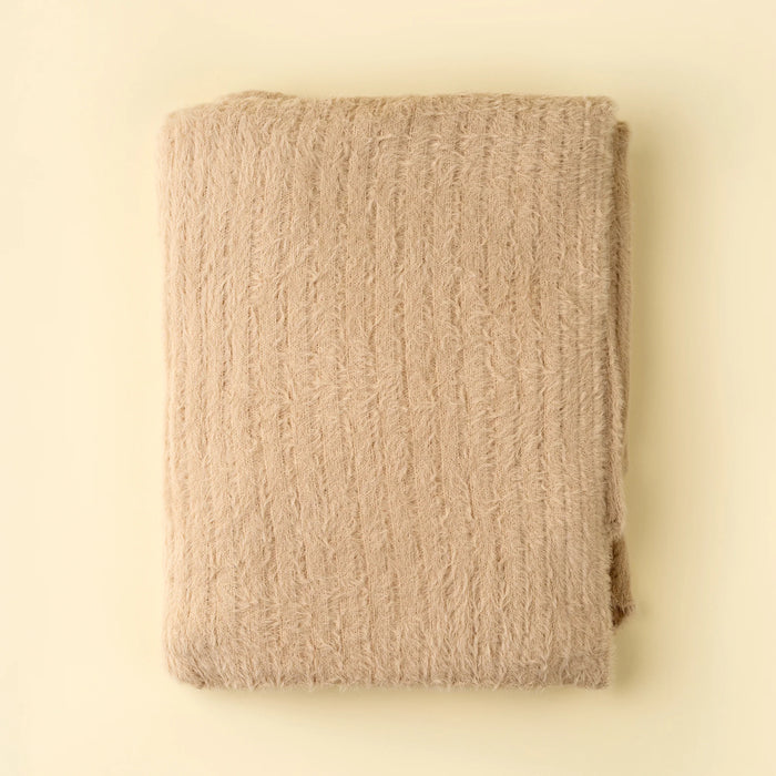 Folded Indaba Snug Throw in warm oat with a soft, fluffy texture