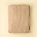 Folded Indaba Snug Throw in warm oat with a soft, fluffy texture