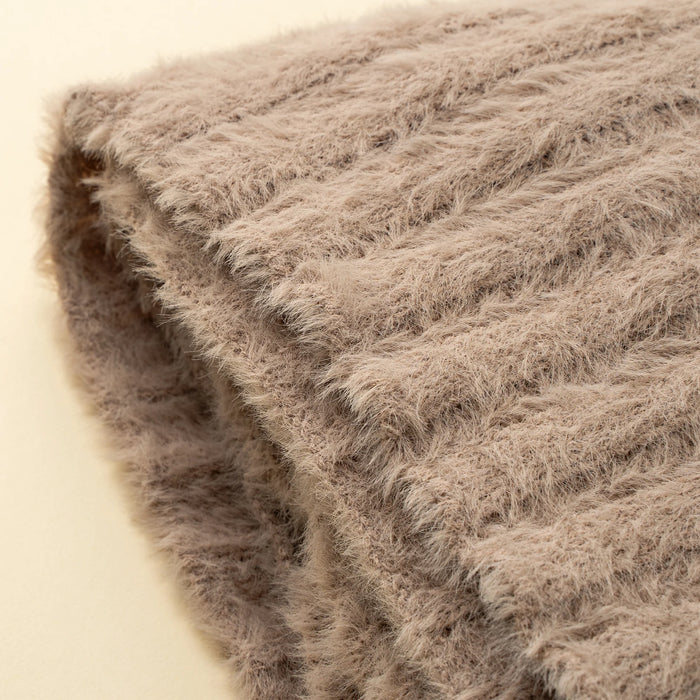 Close-up of the Tuffet Snug Throw showing its soft fibres, knitted texture and finished edge