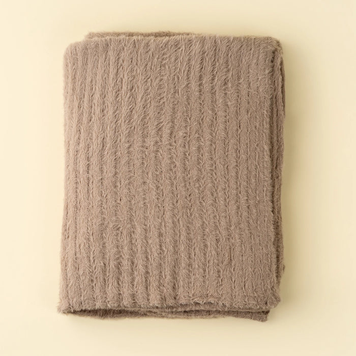 Folded Indaba Snug Throw in Tuffet, showing its warm taupe colour and fluffy knit texture