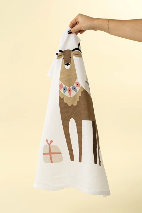 Cream flour sack tea towel hanging from its loop, displaying a stag and holiday gift illustration