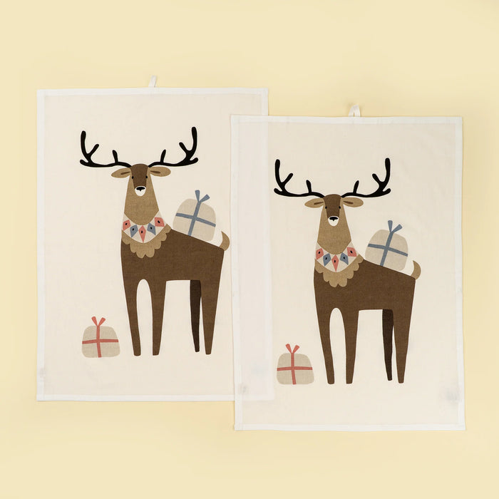 Two cream cotton tea towels featuring brown stags with black antlers and wrapped gifts